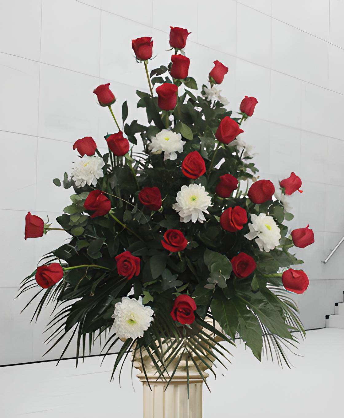 Centro funerario con rosas rojas y margaritas blancas
